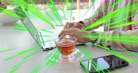 Typing on Laptop with Glass Tea Cup and Smartphone, Wristwatch, Green Motion Streaks