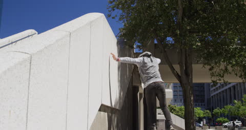 Man Practicing Parkour in Urban Cityscape on Sunny Day