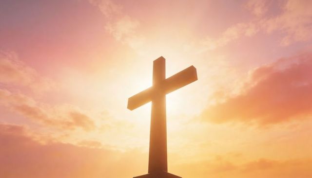 Sunlit cross silhouette on hilltop with haloed sunrise clouds conveying faith and hope