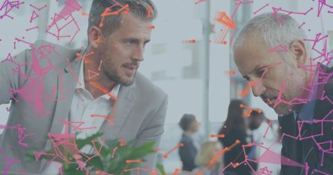 Two professionals collaborating with magenta orange network overlay in modern office