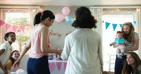 Diverse Friends Celebrating Baby Shower in Festive Home Setting