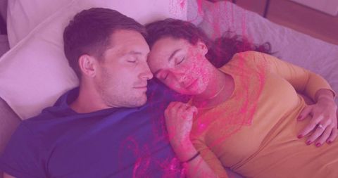 Couple resting on bed showing engagement ring sharing tender romantic moment magenta glow