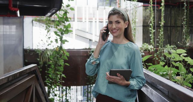 Happy Businesswoman Discussing Work on Phone in Eco-friendly Office - Download Free Stock Images Pikwizard.com