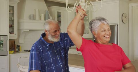 Joyful Senior Couple Dancing in Kitchen Setting