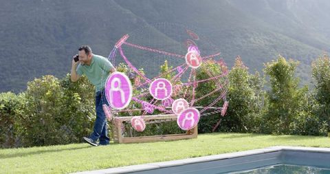 Walking asian man using smartphone by backyard pool with magenta holographic network sphere