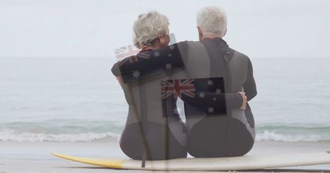 Senior couple embracing on surfboard at beach