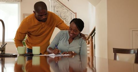 Mature Couple Reviewing Documents with Coffee at Home