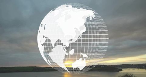 Glowing Wireframe Globe Overlaying Coastal Sunset Horizon Reflecting on Calm Water