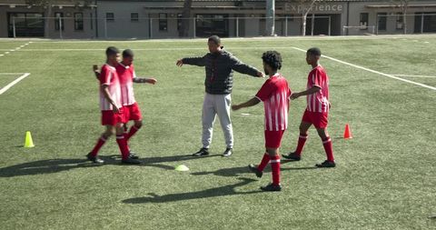 Young soccer players receiving guidance from coach during practice