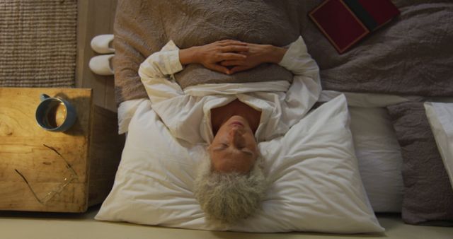Senior biracial woman lying in bed sleeping - Download Free Stock Photos Pikwizard.com