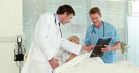 Medical Professionals Consulting with Patient Reviewing Chart in Hospital Room