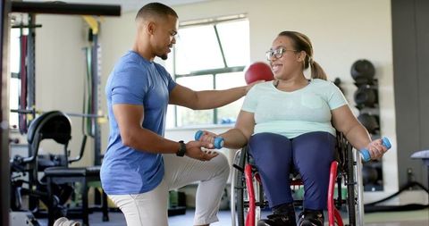 Therapist Assisting Woman in Wheelchair with Exercising