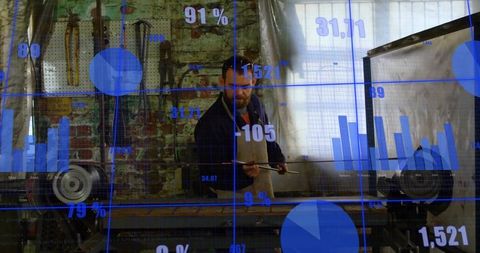 Glassblower in workshop analyzing data graphics