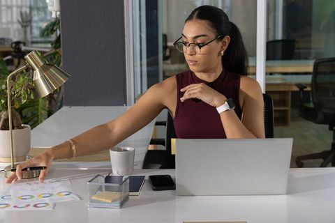 Young asian businesswoman analyzing pie charts while working at modern office desk