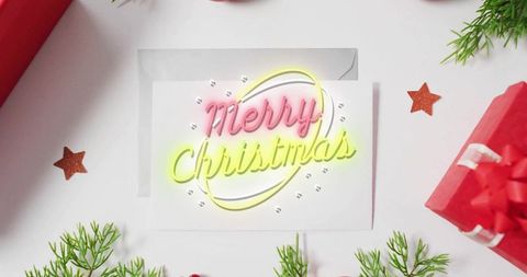 Neon merry christmas greeting card flatlay with evergreen sprigs, red gift box, ribbon