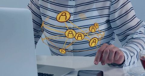Woman tapping smartphone at desk with holographic gold network icons connecting team