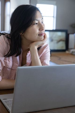Thoughtful Woman in Modern Home Workspace