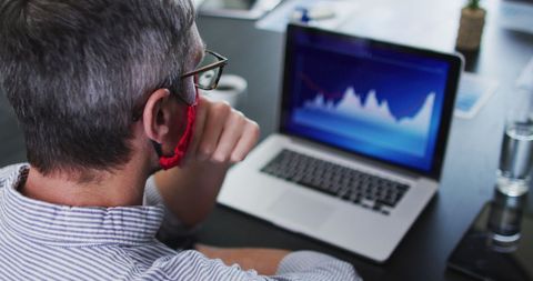 Business Professional Analyzing Financial Graph on Laptop