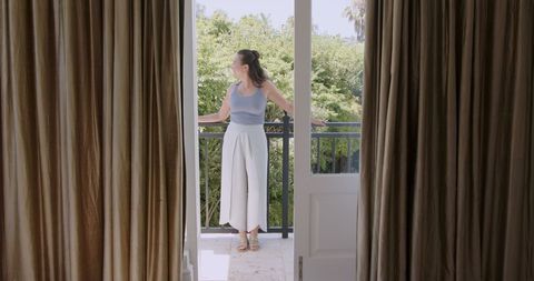 Woman enjoying fresh air on balcony surrounded by greenery