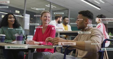 Diverse team collaborating in modern open-plan office with augmented reality id overlays