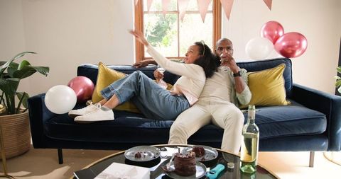 Diverse Couple Celebrating at Home with Wine and Cake