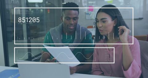 Diverse Team Analyzing Data and Financial Reports in Modern Office