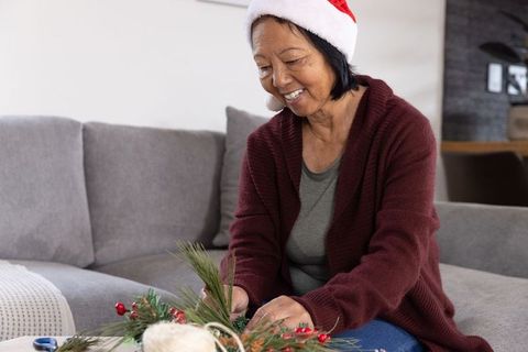 Senior Woman Crafting Christmas Centerpiece with Santa Hat