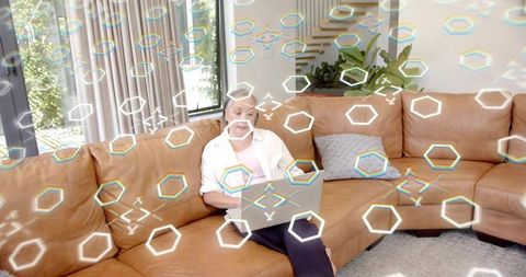 Mature asian woman working on laptop on leather sofa in living room with ar overlay