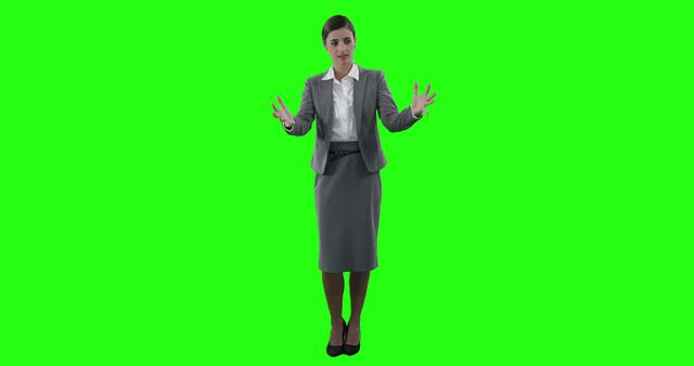 Businesswoman wearing formal attire is using expressive hand gestures to explain or emphasize a point, standing isolated on a green screen background. This image is excellent for use in corporate presentations, training materials, promotional content, advertisements, business blogs, and websites. The green screen allows for easy background replacement.