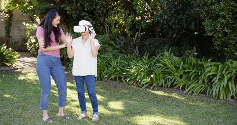 Mother and Daughter Using Virtual Reality Headset in Backyard
