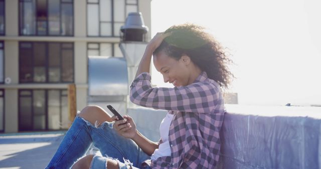 Young Woman Enjoying Sunny Day on Rooftop with Smartphone - Download Free Stock Images Pikwizard.com