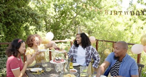 Multiracial Friends Celebrating Birthday on Sunlit Terrace