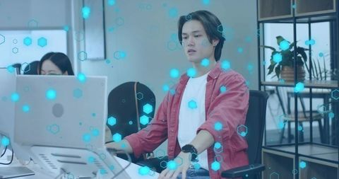 Digital innovator typing at tech office desk with data overlay