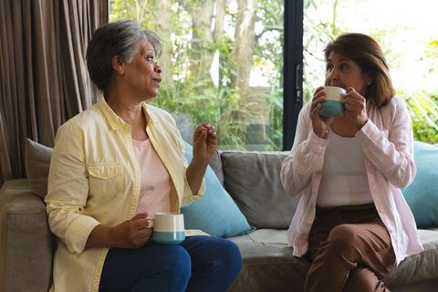 Senior Women Friends Enjoying Coffee and Conversation on Couch
