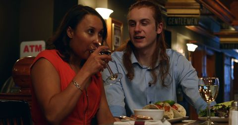 Diverse Friends Enjoying Dinner and Conversations in Cosy Restaurant
