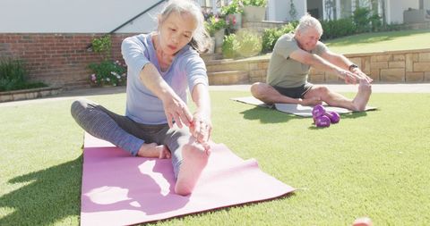 Senior Couple Enjoys Yoga and Stretching in Sunny Garden Setting