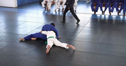 Martial Artists Grappling in Gym During Competitive Match