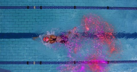Dynamic Female Swimmer in Lane with Vibrant Particle Trail
