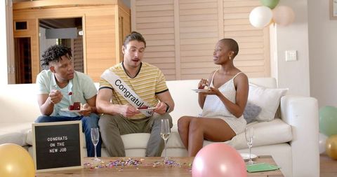 Diverse friends celebrating new job with cake and champagne at home