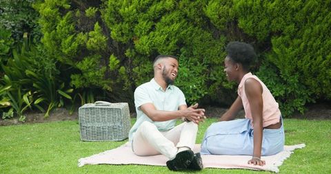 Laughing Couple Enjoying a Picnic in Vibrant Garden