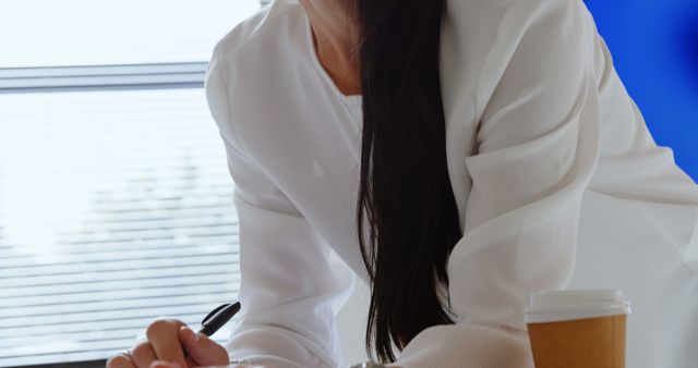 Businesswoman Writing in Office with Coffee Cup - Download Free Stock Images Pikwizard.com