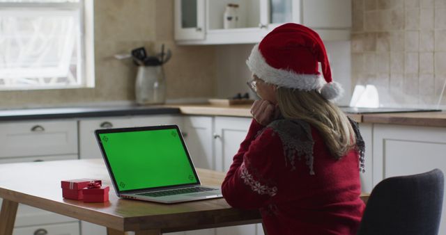 Woman in Santa Hat Video Calling on Laptop in Festive Kitchen - Download Free Stock Images Pikwizard.com