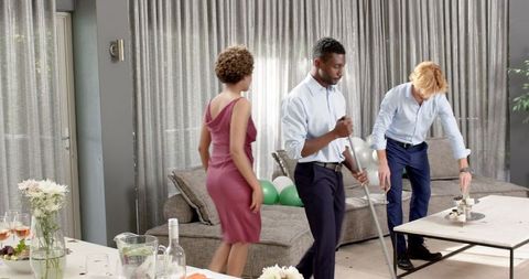 Friends Cleaning Living Room After Wedding Reception Gathering
