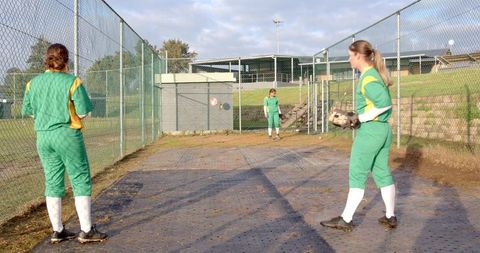 Female Softball Teammates Practicing in Bullpen on Sunny Day