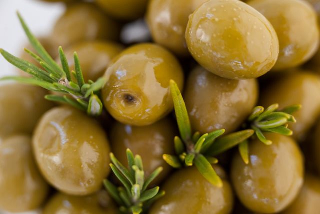 Extreme close up of green olives with herb