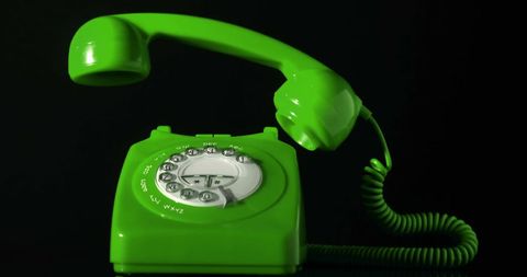 Retro green rotary phone on glossy black background