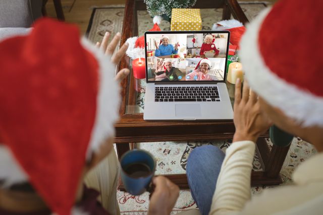 Diverse couple with santa hats having video call with happy diverse friends. Christmas, celebration and digital composite image.