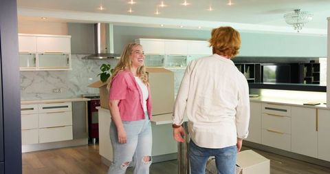 Couple Enjoying Unpacking in New Kitchen
