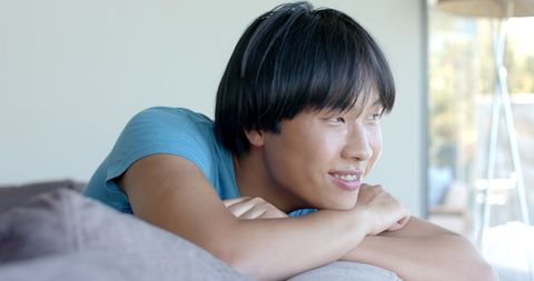College Student Relaxing on Couch in Blue T-Shirt