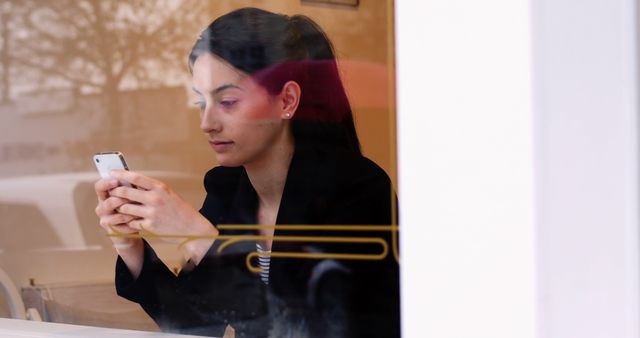 Young Woman Engaging with Smartphone at Cafe Window - Download Free Stock Images Pikwizard.com